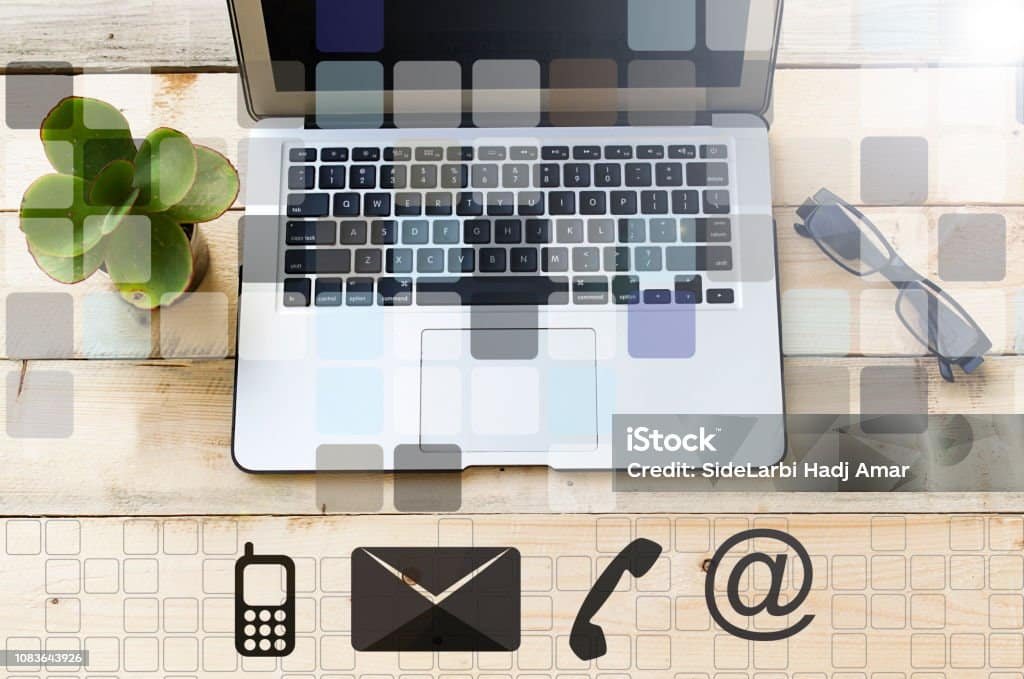 Professional work desk with a laptop and visual elements representing contact information, communication, and customer service.